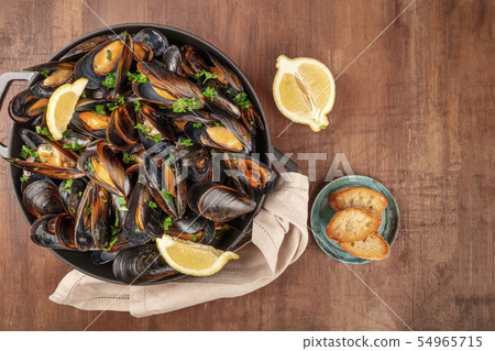Marinara mussels, moules mariniere, with toasted bread and lemon slices, in a cooking pot, shot from Marinara mussels, moules mariniere, with toasted bread and lemon slices, in a cooking pot, shot from 54965715