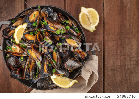 Marinara mussels, moules mariniere, with lemon slices, in a cooking pot, shot from the top Marinara mussels, moules mariniere, with lemon slices, in a cooking pot, shot from the top 54965716