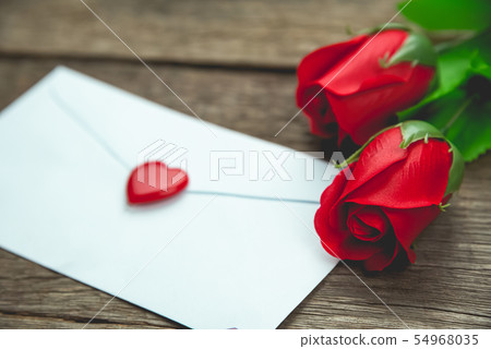 red rose flowers and letter on wood table red rose flowers and letter on wood table 54968035