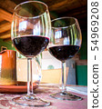 Glass of red wine on a table in rustic restaurant. 54969208