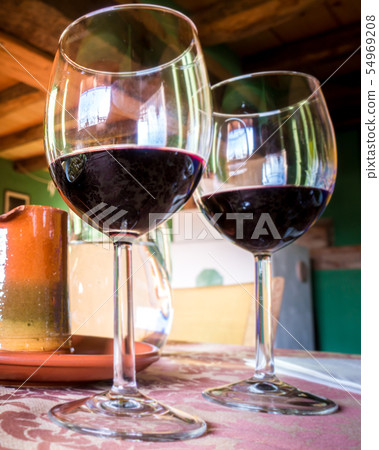 Glass of red wine on a table in rustic restaurant. Glass of red wine on a table in rustic restaurant. 54969208