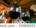 Glass of red wine on a table in rustic restaurant. 54969209