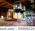 Glass of red wine on a table in rustic restaurant. 54969210