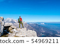 Hiker on the top in mountains. Travel sport 54969211