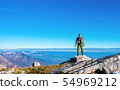 Hiker on the top in mountains. Travel sport 54969212