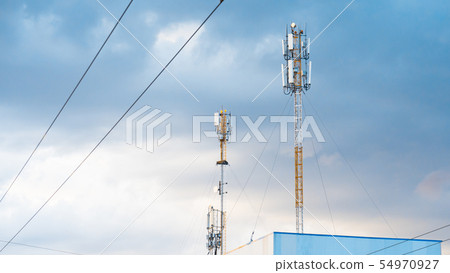 Cellular phone antennas on a building roof. Cellular phone antennas on a building roof. 54970927