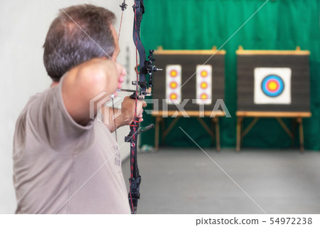 Senior Archer Training With The Bow. Shooting the target in the background. 54972238