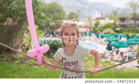 Little girl with a balloon in the shape of a saber Little girl with a balloon in the shape of a saber 54972413