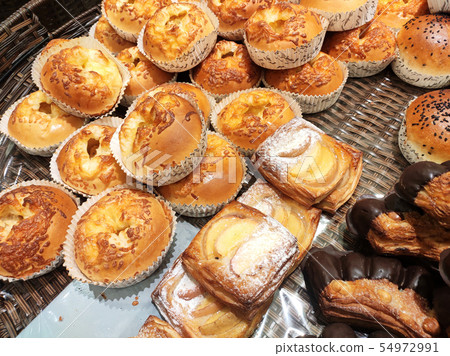 Various types of bread are displayed for sale.  54972991