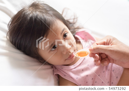 Unhappy asain girl when taking medicine syrup from 54973292