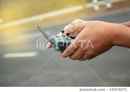 hands with remote controller of drone outside. 54974671