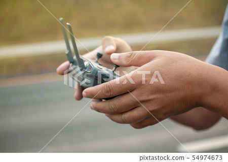 hands with remote controller of drone outside. 54974673