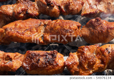 Grilled pork shish kebab cooking on skewers grill 54976134