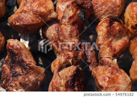 Appetizing juicy pork shish kebabs cooking on gril Appetizing juicy pork shish kebabs cooking on gril 54976182
