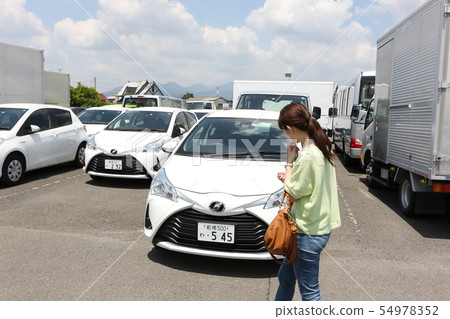 Young woman looking for a car Young woman looking for a car 54978352