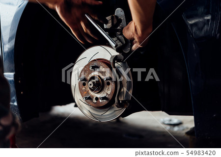 Disc brake and asbestos brake pads at car garage 54983420