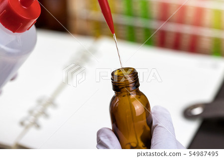 Researcher is dropping the reagent into test tube Researcher is dropping the reagent into test tube 54987495