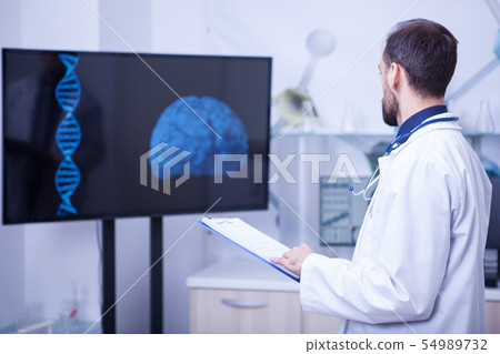 Doctor in his cabinet looking at a braind and trying to put a diagnosis 54989732