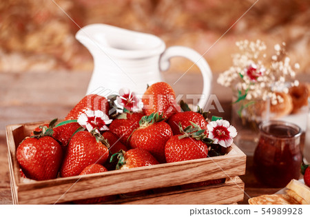 Strawberries in the basket with white jug 54989928