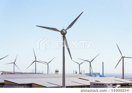 White turbines at wind farm with power station 54998854
