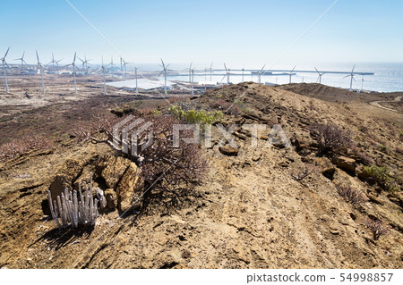 White turbines at wind farm with power station 54998857
