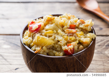 Pilaf with vegetables and chicken in wooden bowl Pilaf with vegetables and chicken in wooden bowl 54998885