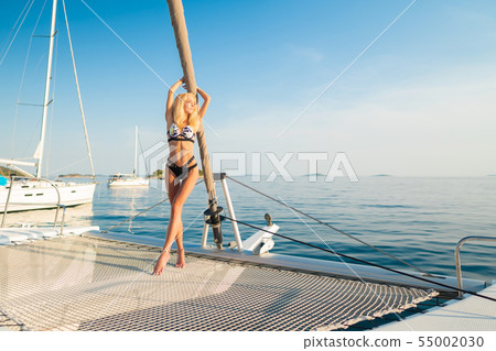beautiful sexy woman in swimwear relaxing on a yacht front beautiful sexy woman in swimwear relaxing on a yacht front 55002030