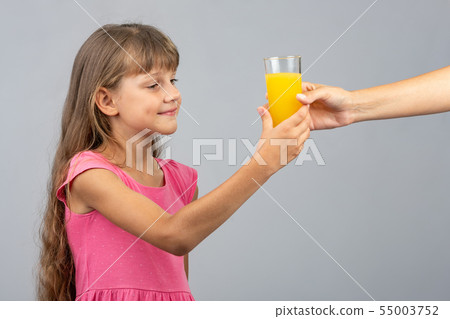 The girl takes from her hand a glass of orange 55003752