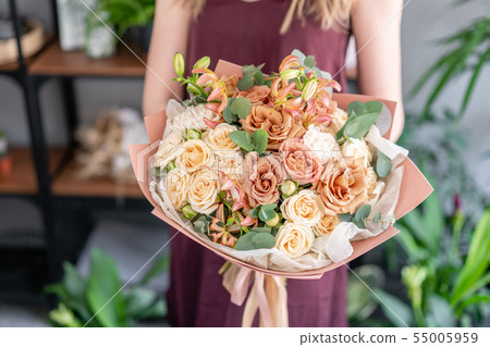 Beautiful bouquet of mixed flowers in woman hand. Floral shop concept . Handsome fresh bouquet 55005959