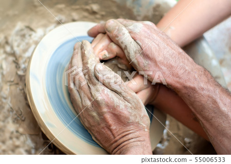two pairs of hands create a clay product on a 55006533