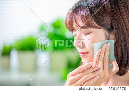 woman use oil blotting paper 55010578