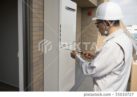 Businessman checking house water heater 55010727