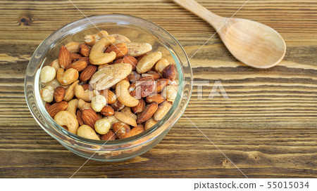 Bake mixed nuts on a wooden table. 55015034