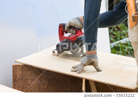 切開與電圓鋸的表面飾板的工匠的手的特寫鏡頭 55015222