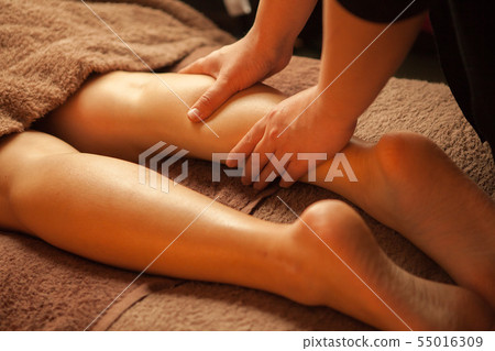 Hand of an esthetician who drains calf's lymph in a beauty salon 55016309