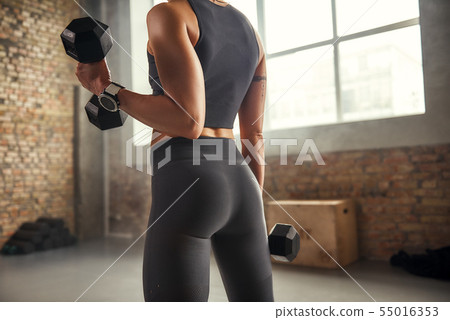 Perfect in everything. Close up of athletic woman with tattoo on her hand wearing sportswear and 55016353