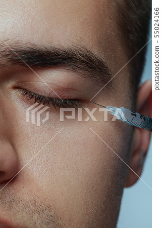 Close-up portrait of young man isolated on grey studio background Close-up portrait of young man isolated on grey studio background 55024166