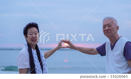Asian senior couple together at sunrise beach. New 55026065