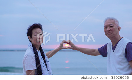 Asian senior couple together at sunrise beach. New Asian senior couple together at sunrise beach. New 55026066