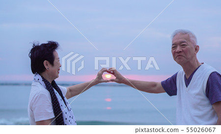 Asian senior couple together at sunrise beach. New Asian senior couple together at sunrise beach. New 55026067