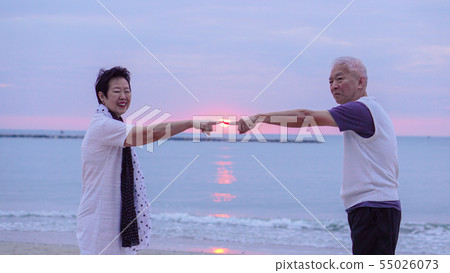 Asian senior couple together at sunrise beach. New Asian senior couple together at sunrise beach. New 55026073