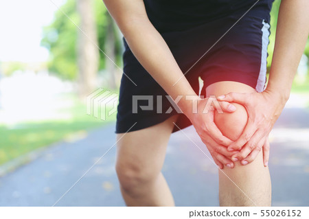 Runner touching painful twisted or broken ankle.  55026152