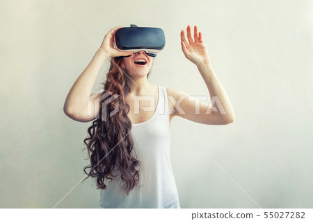 Smile young woman wearing using virtual reality VR glasses helmet headset on white background 55027282