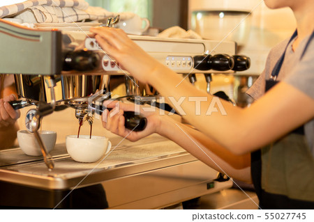 Barista making fresh coffee with machine in coffee shop or cafe. Barista making fresh coffee with machine in coffee shop or cafe. 55027745