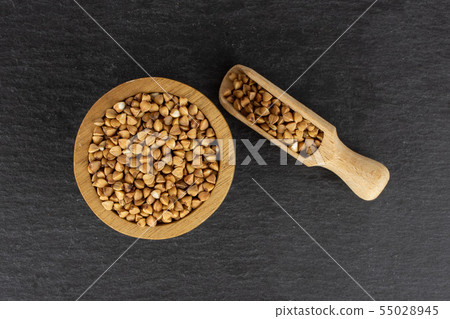 Raw buckwheat grain on grey stone Raw buckwheat grain on grey stone 55028945