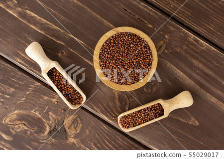 Red quinoa seeds on brown wood 55029017