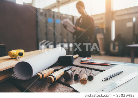 Equipment on wooden desk with man working in Equipment on wooden desk with man working in 55029482