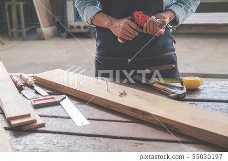 Carpenter working with equipment on wooden table 55030197
