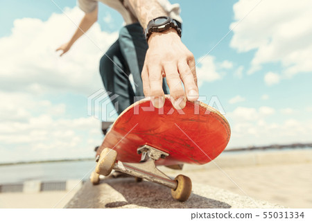 Skateboarder doing a trick at the city's street in sunny day Skateboarder doing a trick at the city's street in sunny day 55031334