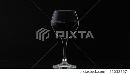 Rose wine. Red wine in wine glass over black background. Silhouette Rose wine. Red wine in wine glass over black background. Silhouette 55032867